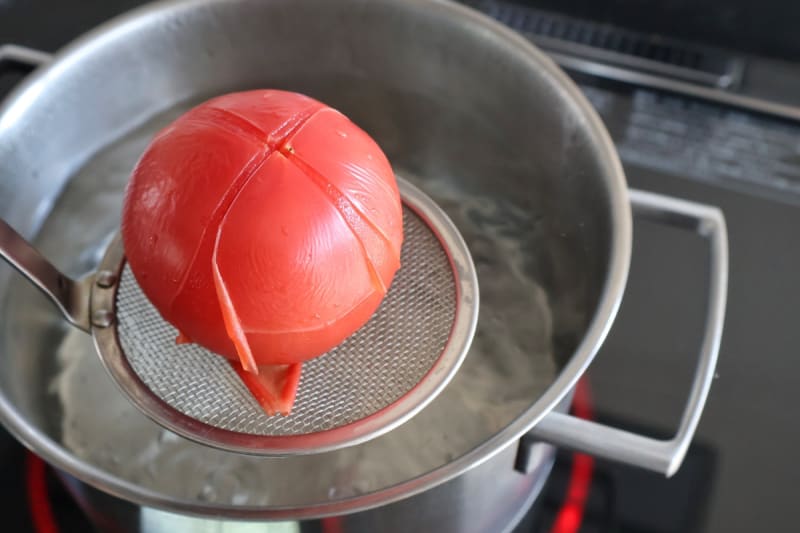 沸騰したお湯にトマトをやさしく入れる