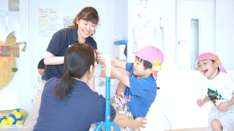 杉山さんと子ども達が鉄棒をしている様子